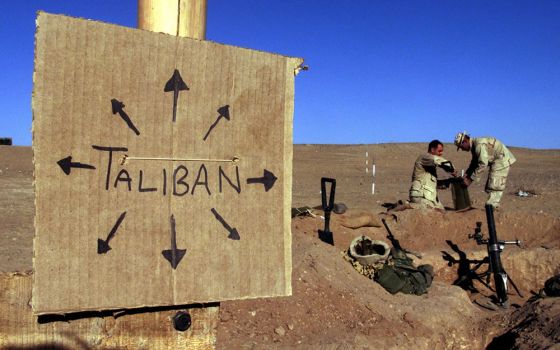 Marines from Charlie 1/1 of the 15th Marine Expeditionary Unit in southern Afghanistan fill sandbags around their light mortar position on the front lines of a Marine Corps base Dec. 1, 2001. (CNS/Reuters/Jim Hollander)