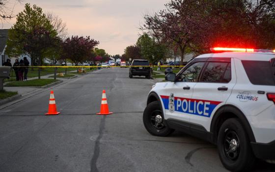 Investigators work at the scene where Ma'Khia Bryant, a 16-year-old Black girl, was fatally shot by a police officer April 20. (CNS/Reuters/Gaelen Morse)