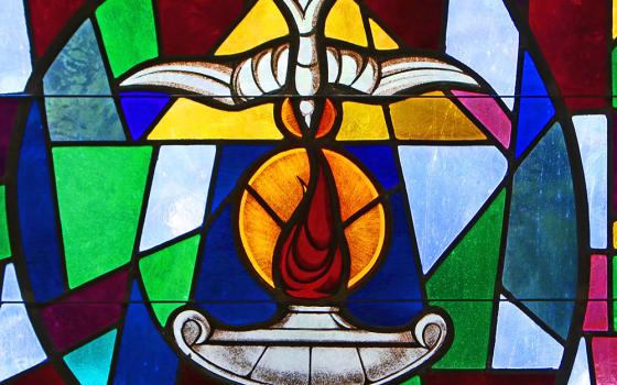 The Holy Spirit and a lantern flame symbolizing the sacrament of confirmation are depicted in a stained-glass window at Sts. Cyril & Methodius Church in Deer Park, New York. (CNS/Gregory A. Shemitz)