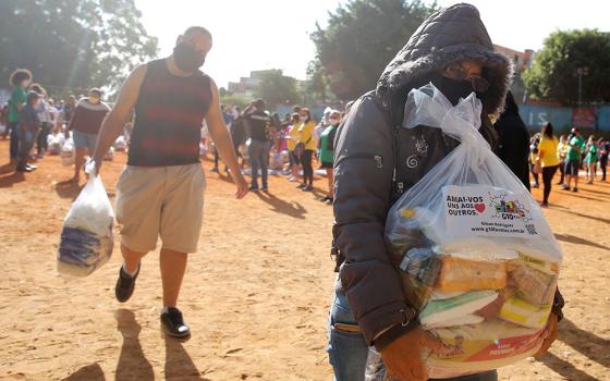 People in need receive food aid in São Paulo April 14 during the COVID-19 pandemic. (CNS/Reuters/Carla Carniel)