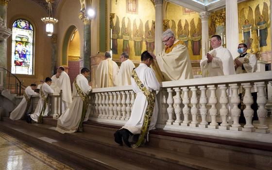 Four ordinands kneel as priests lay hands on them during their ordination to the priesthood June 5 at the Co-Cathedral of St. Joseph in Brooklyn, New York. (CNS/Gregory A. Shemitz)