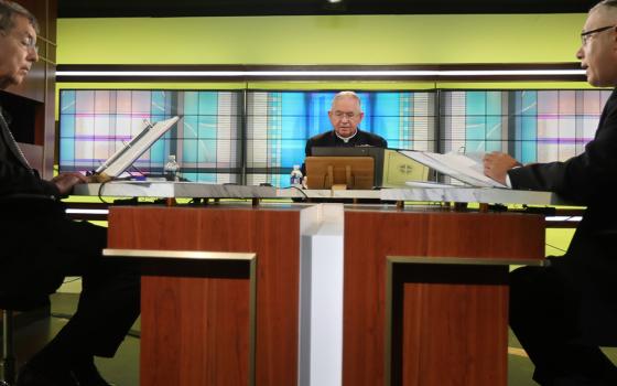 Msgr. Jeffrey Burrill, general secretary of the U.S. Conference of Catholic Bishops, right, reads a message to Pope Francis June 16, at the bishops' conference headquarters in Washington on the opening day of the bishops' three-day virtual spring meeting.