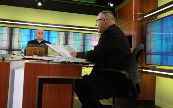 Los Angeles Archbishop José Gomez, president of the U.S. Conference of Catholic Bishops, looks on as Msgr. Jeffrey D. Burrill, the conference's general secretary, reads a message to Pope Francis June 16 at the conference headquarters in Washington. (CNS)