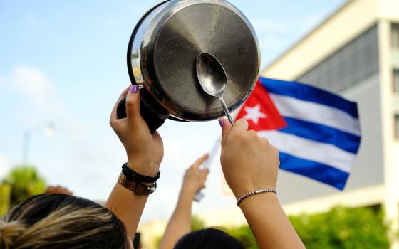 A demonstrator in the Little Havana neighborhood of Miami bangs on a pot July 12 as people rally in solidarity with protesters in Cuba. (CNS/Reuters/Maria Alejandra Cardona)