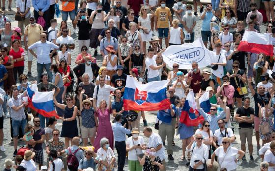 Pilgrims holding the Slovak flag cheer in St. Peter's Square at the Vatican July 4 as Pope Francis announces he will visit their country Sept. 12-15. (CNS/Vatican Media) 