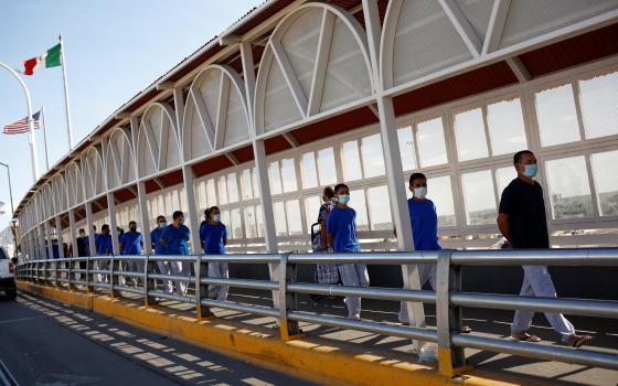 Migrants expelled from the U.S. and sent back to Mexico under Title 42 walk toward Mexico at the Paso del Norte International border bridge, in this picture taken from Ciudad Juarez, Mexico, July 29, 2021. (CNS photo/Jose Luis Gonzalez, Reuters)