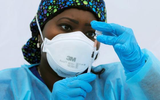 Registered nurse Sheba Phillip prepares a syringe with a dose of the Pfizer-BioNTech COVID-19 vaccine during a vaccination event for local adolescents and adults outside the Bronx Writing Academy school June 4 in New York City. (CNS/Reuters/Mike Segar)