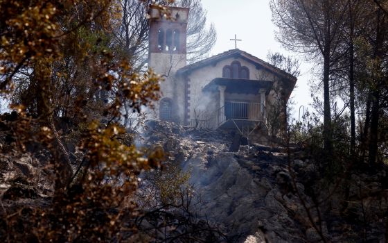 Burned vegetation is pictured near a church at the Monte Catillo nature reserve in Tivoli, Italy, Aug. 13, 2021. Locals were evacuated from small communities near Rome when a wildfire broke out as the Italian capital faced temperatures of around 99 degree