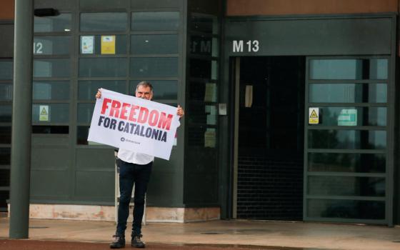 Catalan leader Jordi Cuixart holds a banner in front of the Lledoners prison after the Spanish government announced a pardon for those who participated in Catalonia's failed 2017 independence bid, in this photo taken June 23 in Sant Joan de Vilatorrada.