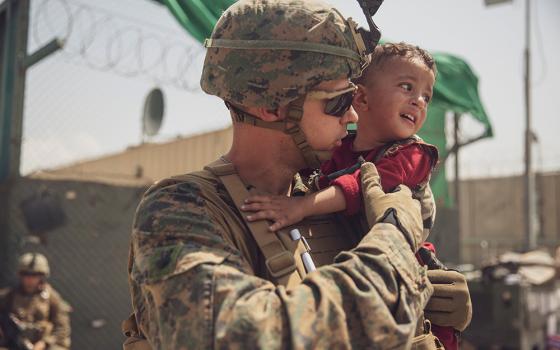 A U.S. Marine calms a toddler during an evacuation at Hamid Karzai International Airport Aug. 22 in Kabul, Afghanistan. (CNS/U.S. Marine Staff Sgt. Victor Mancilla, handout via Reuters)