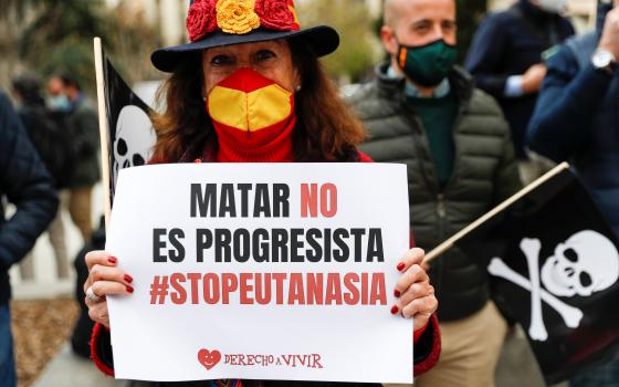 A woman protests against a law to legalize euthanasia as the Spanish Parliament votes to approve it in Madrid March 18, 2021. Her sign reads "Killing is not progressive, stop euthanasia." Increasing calls to legalize euthanasia in several European countri