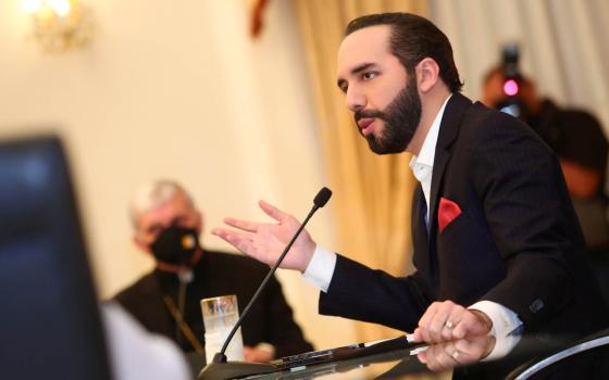 A prelate wearing a protective mask looks on as Salvadoran President Nayib Bukele takes part in a meeting at the Presidential House in San Salvador May 3, 2021. Without naming the president, the bishops said Sept. 12 that making changes without following 