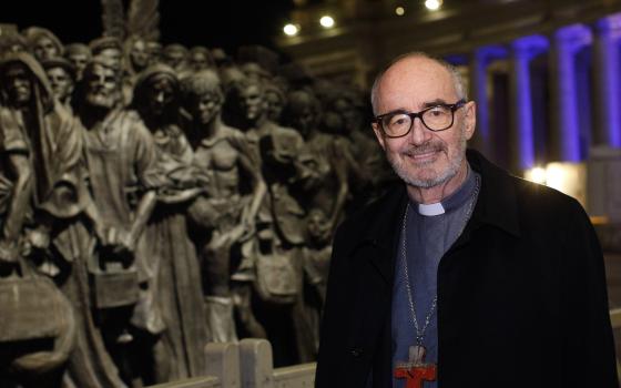 Canadian Cardinal Michael Czerny, undersecretary for migrants and refugees at the Vatican Dicastery for Promoting Integral Human Development, poses for a photo at the "Angels Unawares" statue in St. Peter's Square at the Vatican Dec. 15, 2020. In a virtua