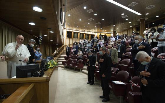 Pope Francis gives his blessing Sept. 16 at the end of a meeting in the Vatican synod hall with members of lay movements. The hall will be the site of the 2023 Vatican event, the final phase of the new process of the Synod of Bishops (CNS/Vatican Media)