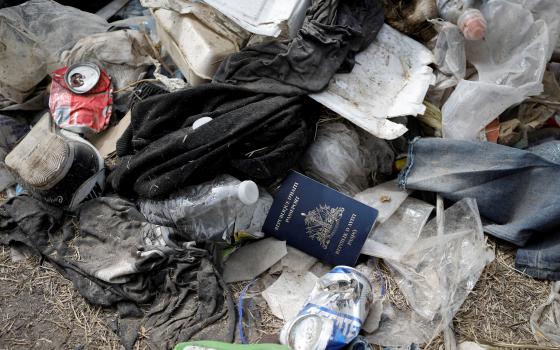 A Haitian passport is seen in a pile of trash Sept. 21, 2021, in Del Rio, Texas, near the International Bridge between Mexico and the United States. (CNS photo/Marco Bello, Reuters)