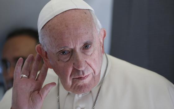 Pope Francis listens to a question while responding to journalists aboard his flight from Tallinn, Estonia, to Rome in 2018. (CNS/Paul Haring)