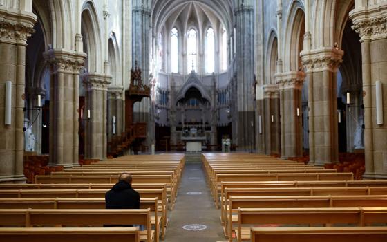 A man prays inside St. Martin Church near Nantes, France, Oct. 5. (CNS/Reuters/Stephane Mahe)