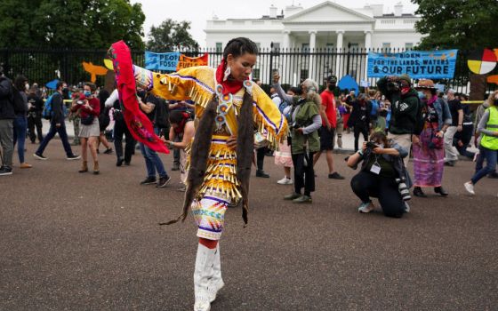 A Native American woman poses for pictures near the White House in Washington Oct. 11, 2021, as people demonstrate during a climate change protest on Columbus Day, also called Indigenous Peoples Day by activist groups. (CNS photo/Kevin Lamarque, Reuters)