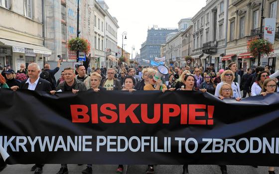 People take part during a demonstration against pedophilia, "Hands away from children," in Warsaw, Poland, Oct. 7, 2018. The banner reads, "Bishop, hiding pedophilia is a crime." (CNS/Agencja Gazeta via Reuters/Jacek Marczewski)