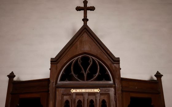 A confessional on which is written: "M. the Priest" is pictured in a Catholic church near Nantes, France, Oct. 5, 2021. Church and government leaders in France are at odds over whether priests should be required to report the abuse of minors if they learn