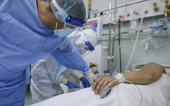 A doctor and nurse at Marius Nasta Pneumology Institute in Bucharest, Romania, take care of a coronavirus patient Oct. 17, 2021. (CNS photo/Inquam Photos, Octav Ganea via Reuters)