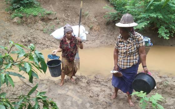 Villagers displaced by fighting in eastern Myanmar cross a river in Kayah state June 12, 2021. (CNS photo/Reuters)