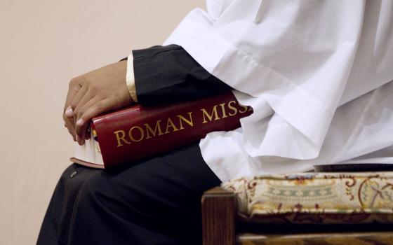 An altar server holds a copy of the Roman Missal during Mass at St. Joseph Catholic Church in Alexandria, Va., in this 2011 file photo. (CNS photo/Nancy Phelan Wiechec)