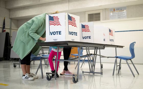 A mother in McLean, Virginia, casts her vote during the governor's race Nov. 2. (CNS/Reuters/Tom Brenner)