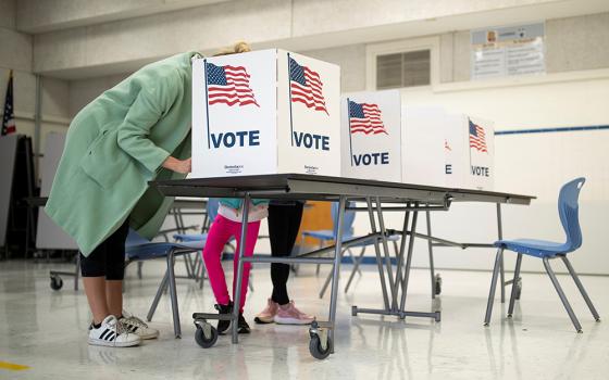 A mother in McLean, Virginia, casts her vote during the governor's race Nov. 2, 2021. (CNS/Reuters/Tom Brenner)