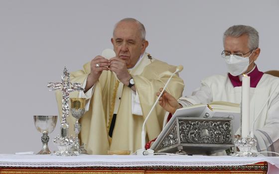 Pope Francis holds the Eucharist as he celebrates Mass at the Catholic University of the Sacred Heart in Rome Nov. 5, 2021. (CNS photo/Paul Haring)