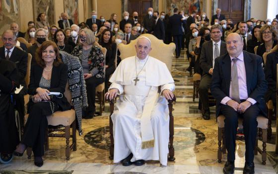 Pope Francis is seated next to Valentina Alazrak of Televisa and Philip Pullella of Reuters during a ceremony to honor the two journalists in the Apostolic Palace at the Vatican Oct. 13, 2021. (CNS photo/Vatican Media)