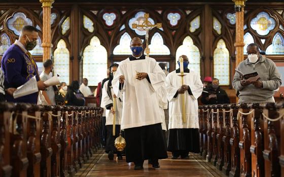 Toby Offiah, a seminarian of the Diocese of Brooklyn, New York, leads the opening procession during a Mass marking Black Catholic History Month Nov. 21, 2021, at Our Lady of Victory Church in the Bedford-Stuyvesant section of Brooklyn. (CNS)