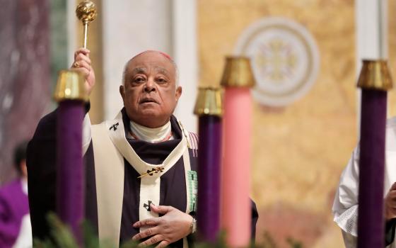 Washington Cardinal Wilton D. Gregory sprinkles holy water to bless the Advent wreath during Mass at St. Matthew's Cathedral Nov. 28, 2021, the first Sunday of Advent. (CNS photo/Andrew Biraj, Catholic Standard)