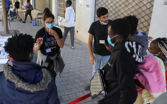 Volunteers assist migrants outside Holy Cross Catholic Church next to the United Nations buffer zone in Nicosia, Cyprus, Nov. 24. (CNS/Reuters/Yiannis Kourtoglou)