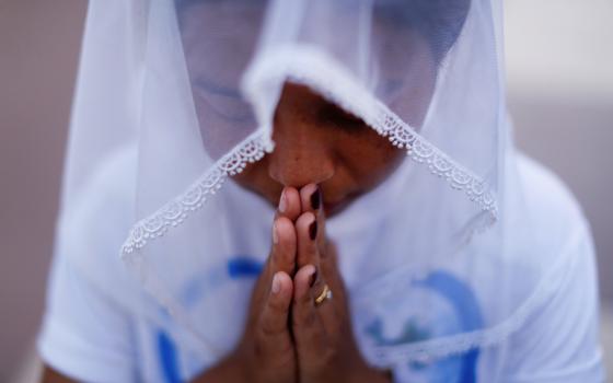 A woman is pictured in a file photo praying at St. Anthony church in Yangon, Myanmar. (CNS photo/Jorge Silva, Reuters)