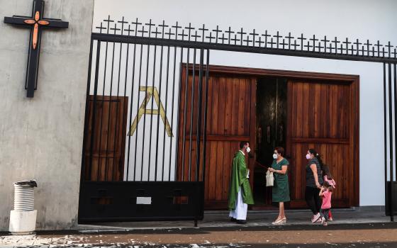 A priest talks with parishioners before celebrating Mass in the Church of San Isidoro in La Palma, Spain, Sept. 25, 2021. (CNS photo/Nacho Doce, Reuters)