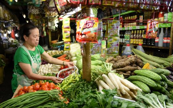 A vendor arranges her vegetables at a market in Manila, Philippines, in this 2018 file photo. A Philippine Catholic foundation will partner with the country's agriculture department to grow vegetables to feed the nation's poor communities. (CNS photo/Dondi Tawatao, Reuters)