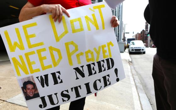 A woman holds this sign as members of the Survivors Network of those Abused by Priests (SNAP) hold a news conference in front of the Diocese of Pittsburgh Aug. 20, 2018, several days after a Pennsylvania grand jury released a stinging report that said more than 300 priests sexually abused more than 1,000 children during the course of several decades. (CNS/Chaz Muth)