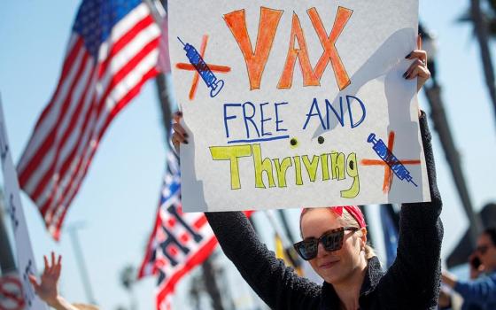 A woman in Huntington Beach, California, holds a sign during a protest about the COVID-19 vaccine mandates for school children and workers Jan. 3. (CNS/Reuters/Mike Blake)