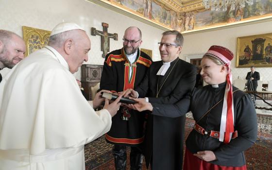 Pope Francis accepts a gift during an audience with an ecumenical delegation from Finland at the Vatican Jan. 17, 2022.  (CNS photo/Vatican Media)