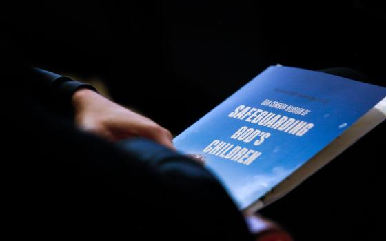 A delegate holds a program during an international conference, "Our Common Mission of Safeguarding God's Children," in Warsaw, Poland, Sept. 21, 2021.(CNS photo/Polish bishops' conference)