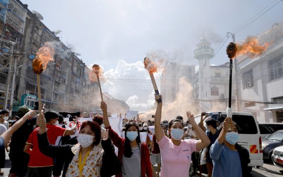 A group of women hold torches as they protest against the military coup in Yangon, Myanmar, July 14, 2021. (CNS photo/Reuters)