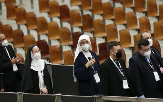 Participants return to their seats after a break during an international symposium on the priesthood at the Vatican Feb. 17, 2022. (CNS photo/Paul Haring)