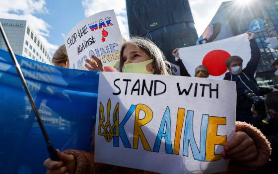 A Ukrainian residing in Japan shows a placard during a protest rally denouncing Russia over its actions in Ukraine, near the Russian Embassy in Tokyo Feb. 23, 2022. (CNS photo/Issei Kato, Reuters)