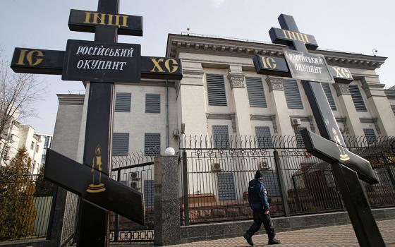 Crosses installed during a protest against Russia's actions in eastern Ukraine are pictured Feb. 23 in front of the Russian Embassy in Kyiv, Ukraine. The signs on the crosses read: "Russian occupier." (CNS/Reuters/Valentyn Ogirenko)