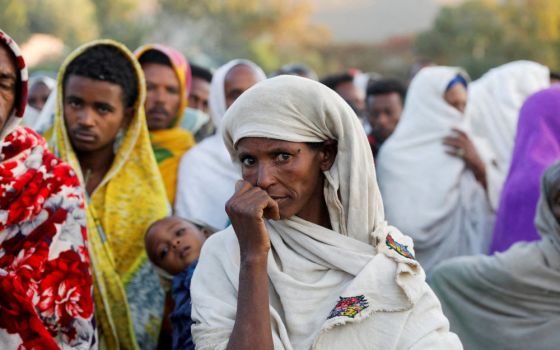 A woman stands in line to receive food donations at the Tsehaye primary school, which was turned into a temporary shelter for people displaced by conflict, in Shire, in Ethiopia's Tigray region. (CNS/Reuters/Baz Ratner)