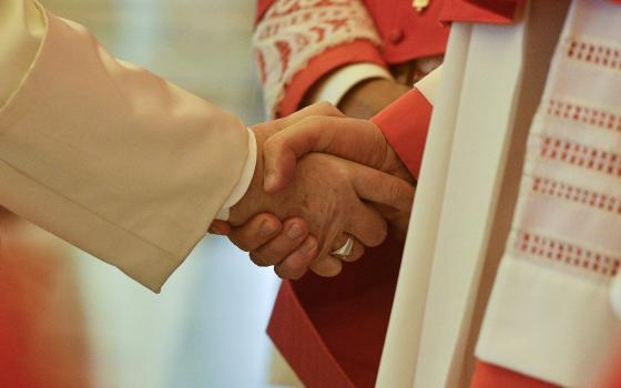 Pope Francis shakes hands with a cardinal during an "ordinary public consistory" for the approval of the canonizations of 10 new saints, at the Vatican March 4, 2022. (CNS photo/Vatican Media)