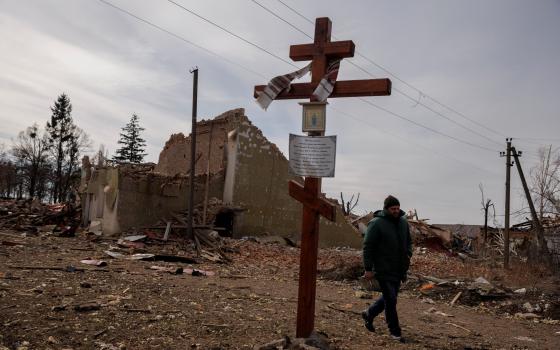 A man walks by the debris of a cultural center and an administration building destroyed during aerial bombing, as Russia's advance on the Ukrainian capital continues, in the village of Byshiv outside Kyiv, Ukraine, March 12, 2022. (CNS photo/Thomas Peter,