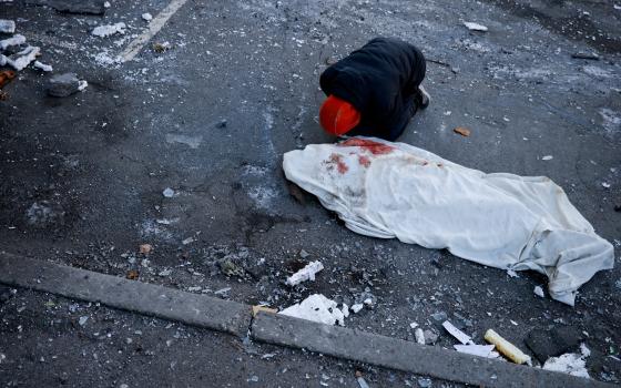 A man in Kyiv, Ukraine, mourns his mother, who was killed when an intercepted missile hit a residential building March 17, 2022. (CNS photo/Thomas Peter, Reuters)