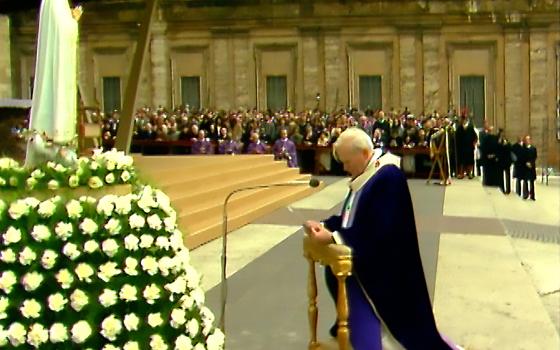 Pope John Paul II kneels in front of the statue of Our Lady of Fatima as he entrusts "all men and women and all peoples to the Immaculate Heart of Mary," in St. Peter's Square at the Vatican in this March 25, 1984, photo. (CNS photo/Vatican Media)